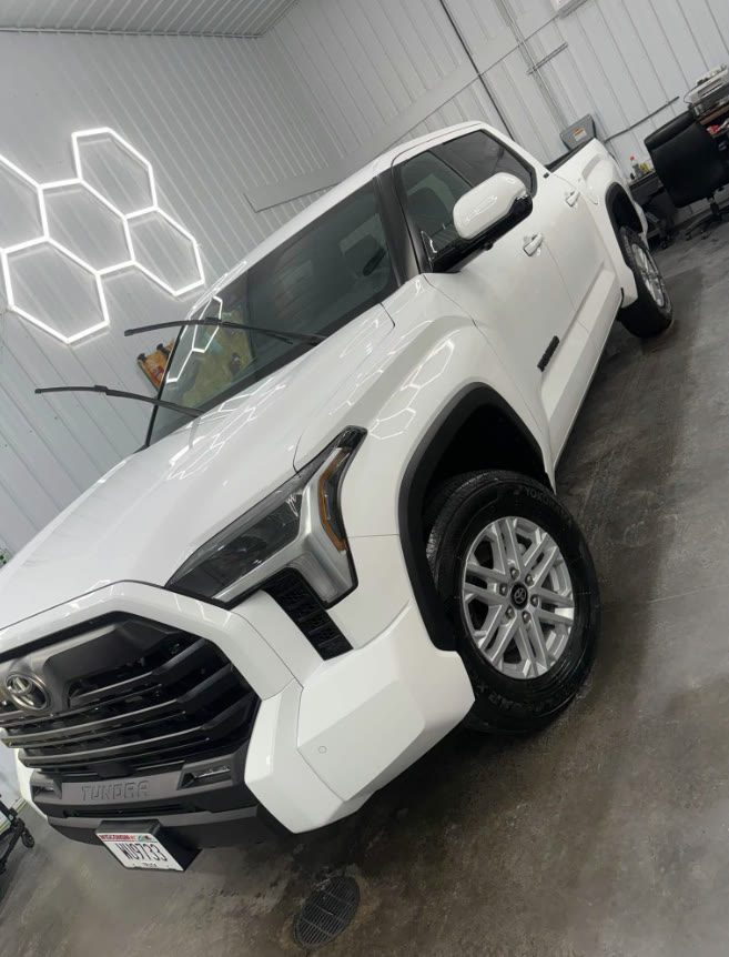 White Toyota Tundra with hexagon light reflections on the hood inside the M&B Auto Detailing bay